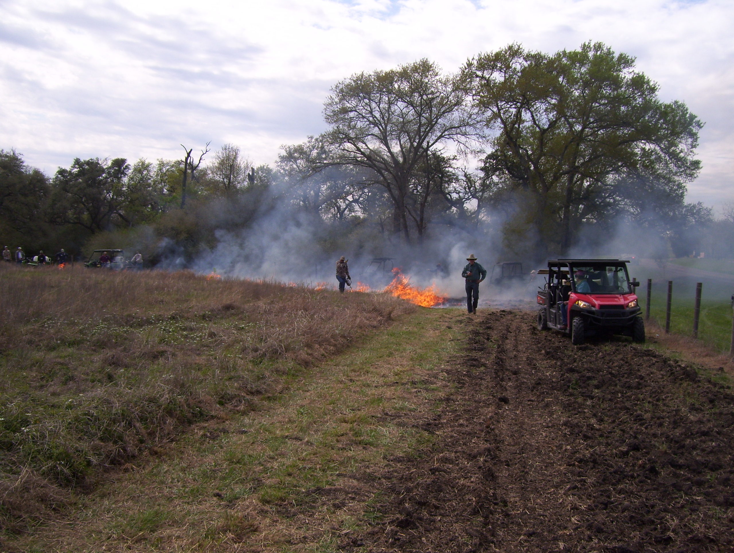 Members on a burn, fire burning in the background
